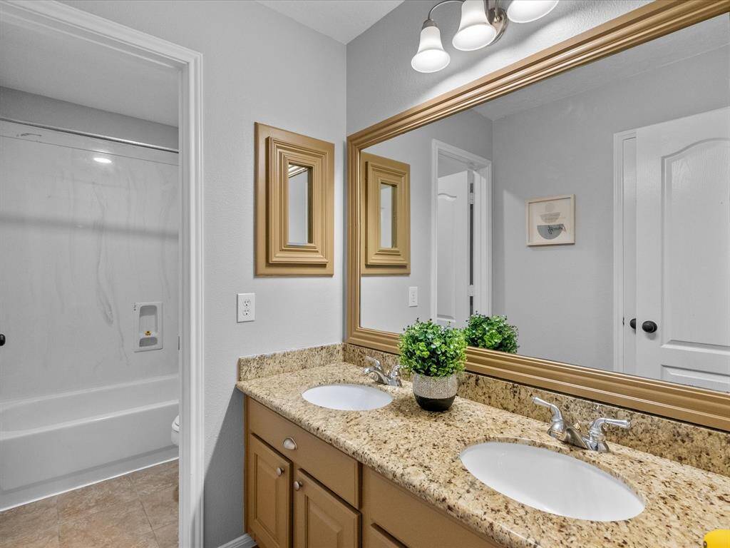 Double vanity bathroom with granite countertops and framed mirrors for a polished look.