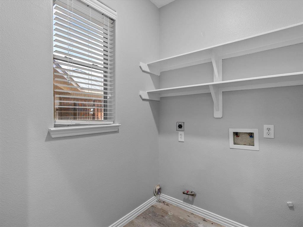 Functional utility room with shelving and space for washer and dryer setup