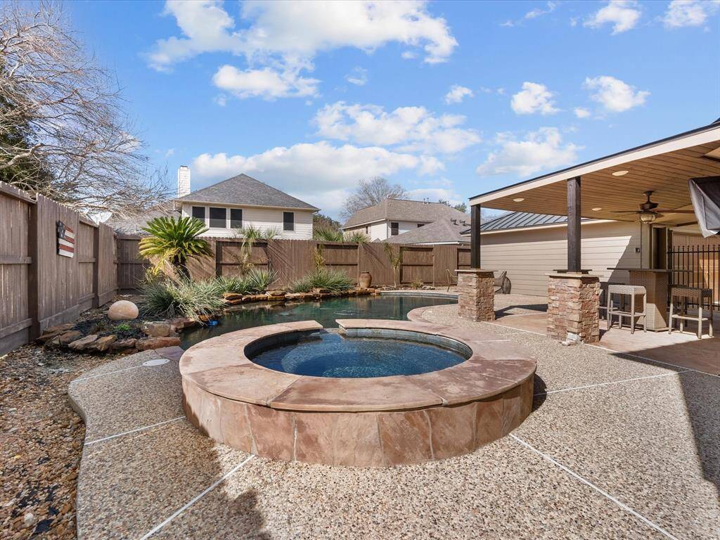 Relax and unwind in the luxurious spa overlooking the serene backyard setting