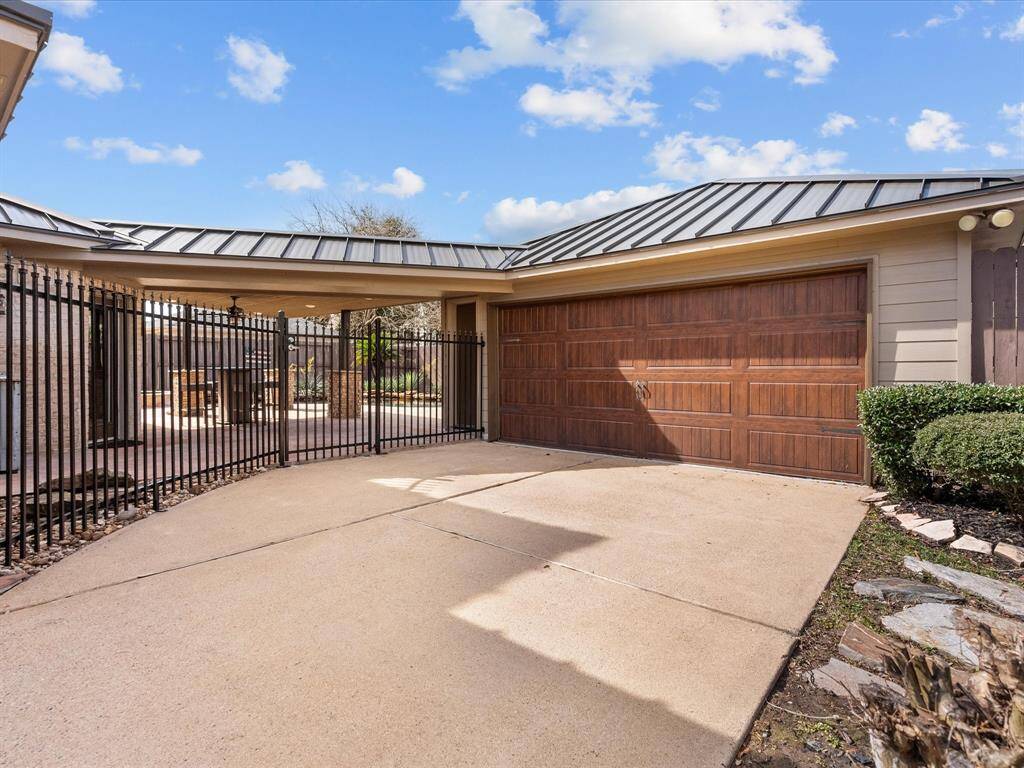 Private gated entry with ample driveway space and stunning wood-style garage door