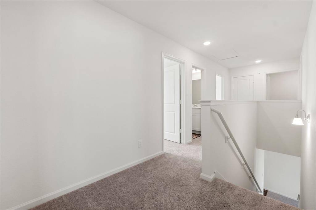 A view of the landing and hallway leading to the secondary bedrooms and laundry room.