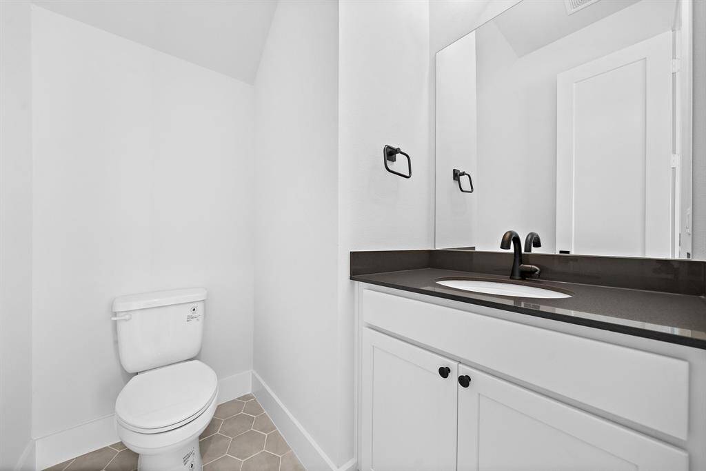 Half bath located off the staircase on the first floor.
