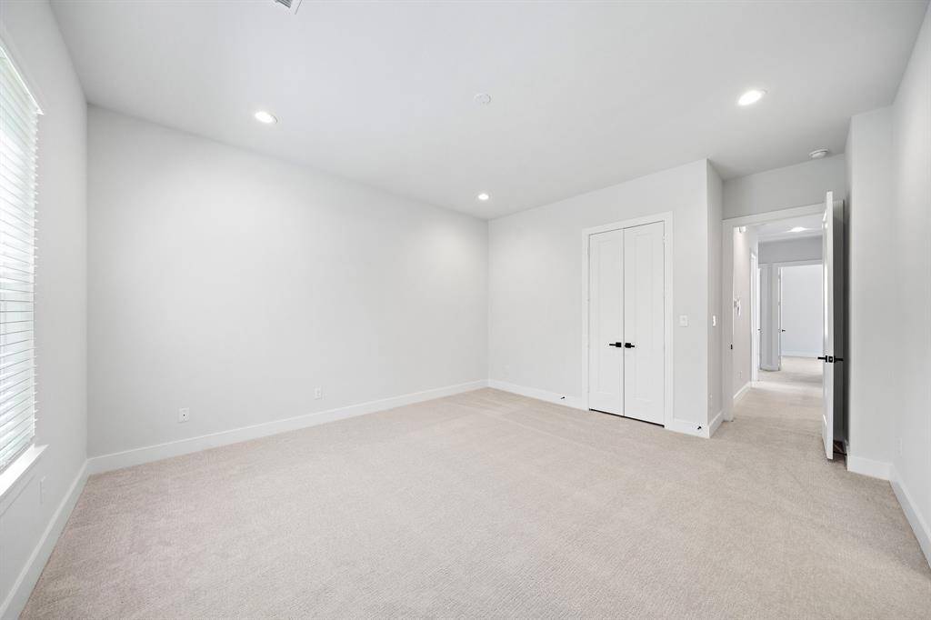 Spacious primary bedroom located on the second floor features ensuite bath, carpet, and two walk in closets.
