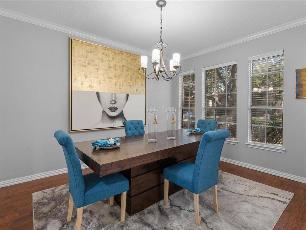 Elegant dining area with large windows, crown molding, archway accents and abundant lighting