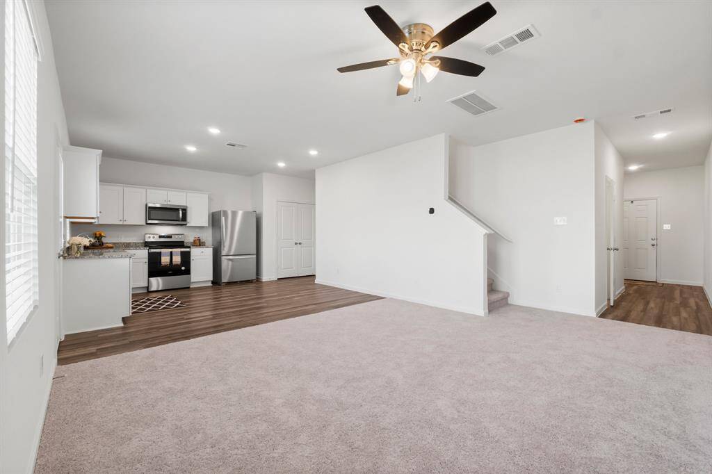 This inviting family room seamlessly flows into the modern kitchen, creating the perfect space for gatherings and everyday living.