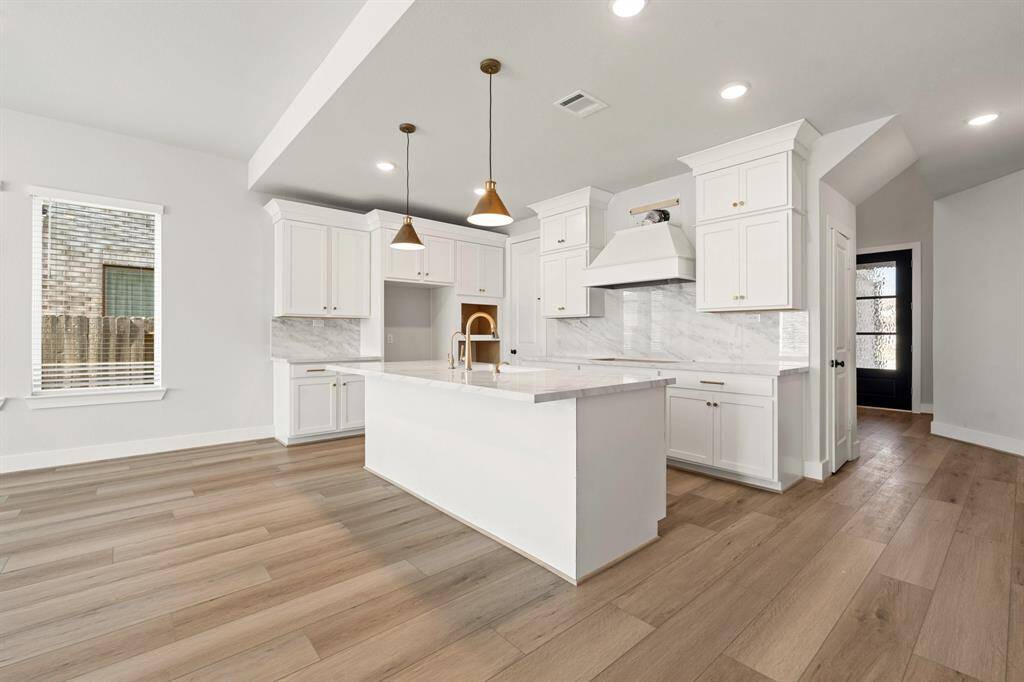 The gourmet kitchen boasts high-end appliances and ample counter space, making it a chef's dream. With custom cabinetry and an inviting layout, it’s perfect for both cooking and entertaining.