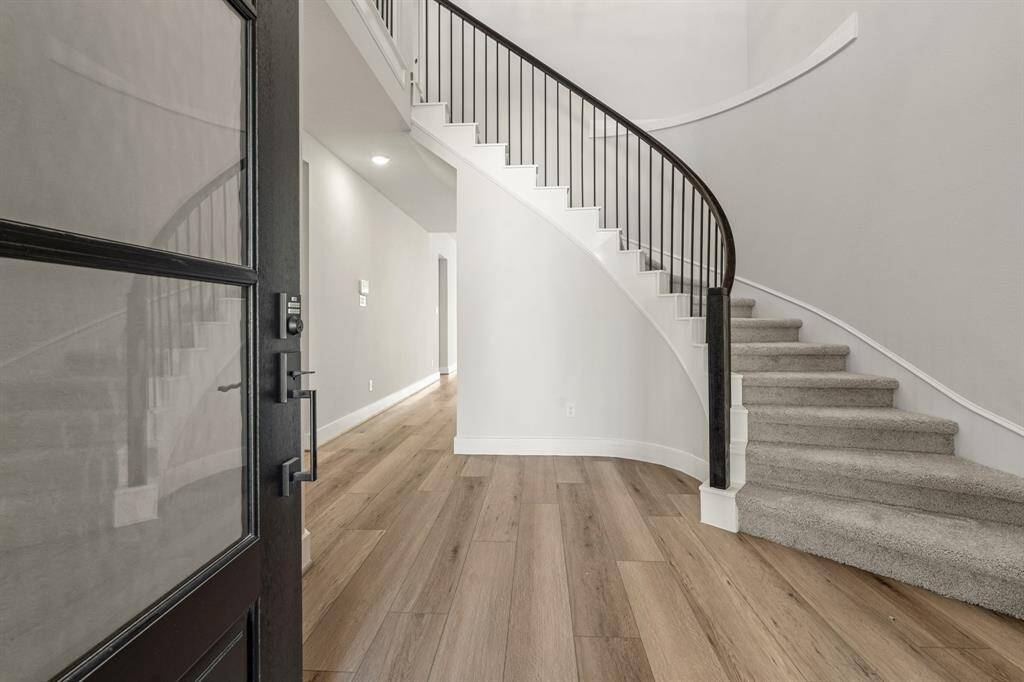 The spiral staircase elegantly winds its way upward, creating a stunning focal point in the room. Its sleek design not only saves space but also adds a touch of sophistication to the home.
