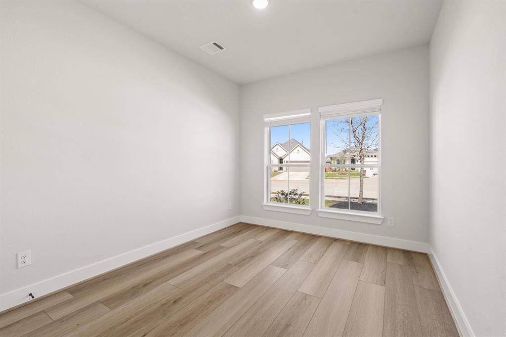 Secondary bedroom (DOWNSTAIRS) features hardwood floors.