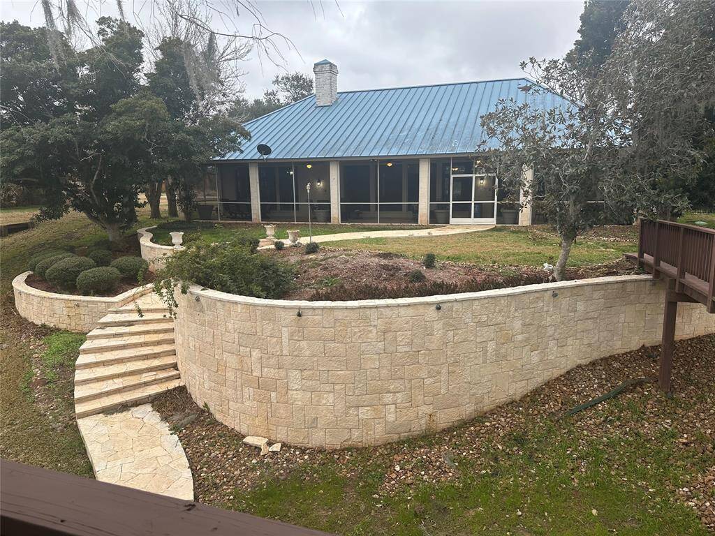 View of magnificent stone retention wall, steps and walkway  around back of house.