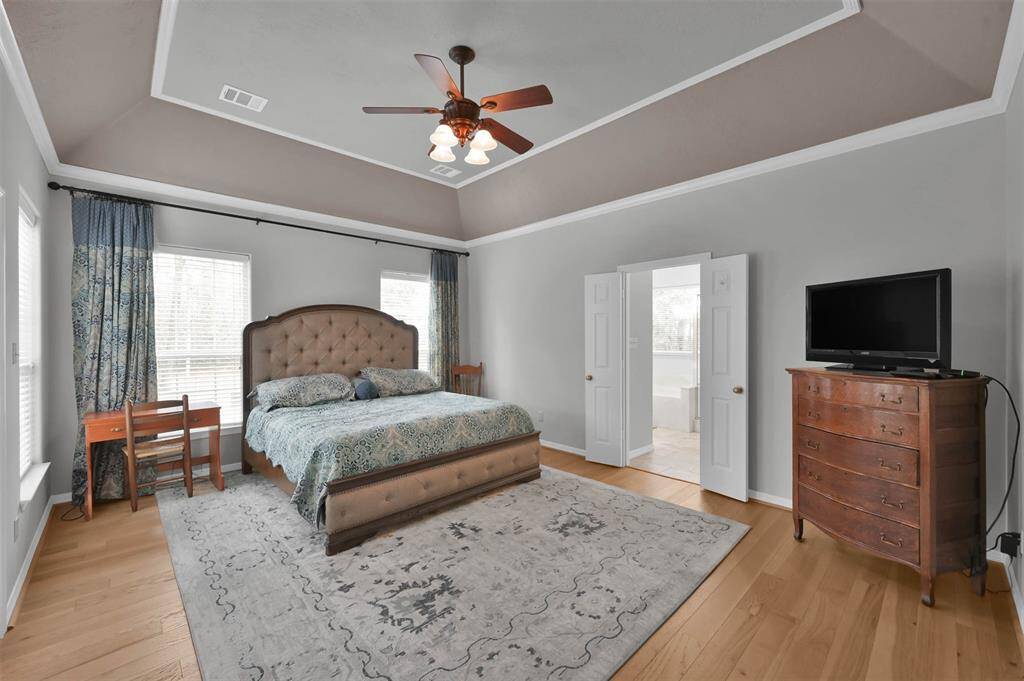 Spacious primary bedroom with elegant tray ceilings and direct patio access.