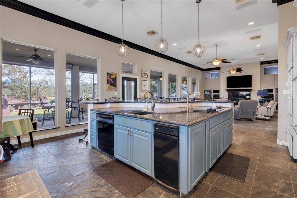 Lovely kitchen has custom cabinets with granite countertops, large island with full length breakfast bar, small breakfast nook all flowing into the spacious living area.