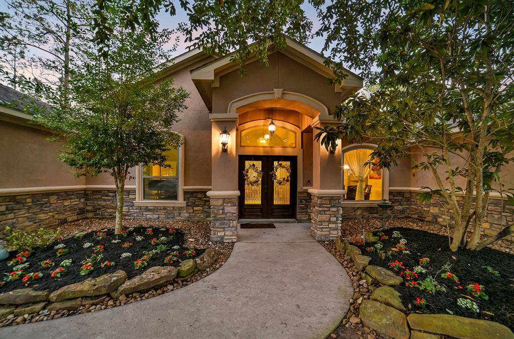 The elegant wood double doors with glass inserts framed by a stucco archway with a gentle path curvature says, "Welcome--and prepared to be wowed!"