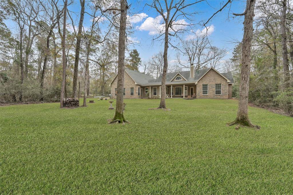 Serene view from the backyard, showcasing the inviting home nestled among mature trees.