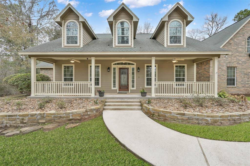 Charming 1.5-story ranch on 2 acres, featuring a welcoming front porch and mature, beautiful landscaping.