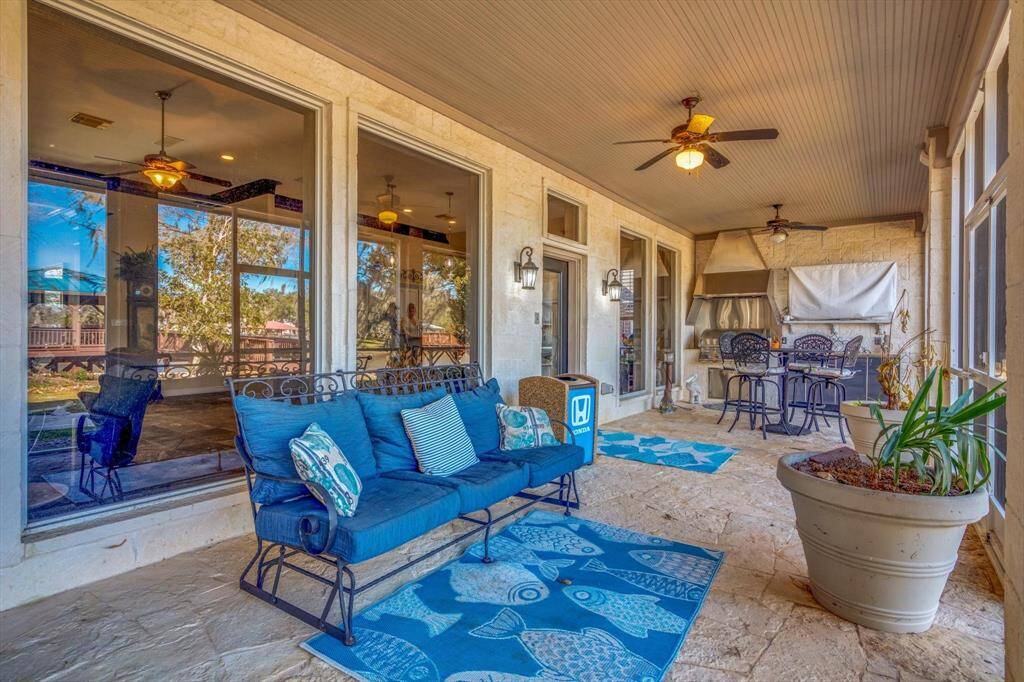 View of screened porch with large TV and outdoor kitchen area.