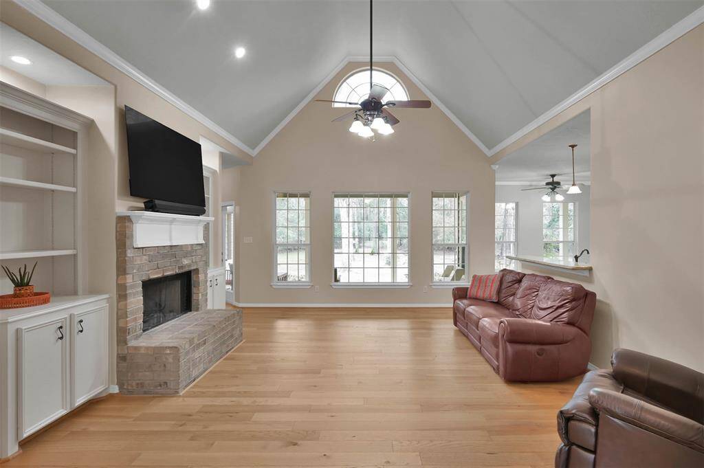 Spacious living room with vaulted ceilings, cozy fireplace, and abundant natural light.