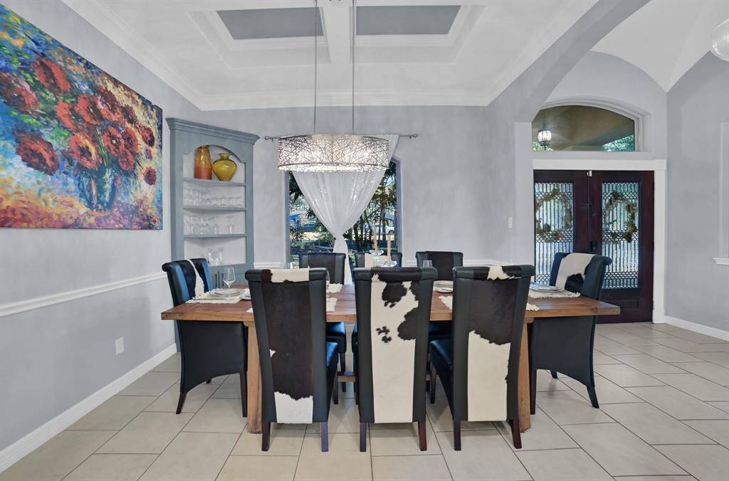 Another angle of this tastfully accented formal dining room with a view of the double door entry.