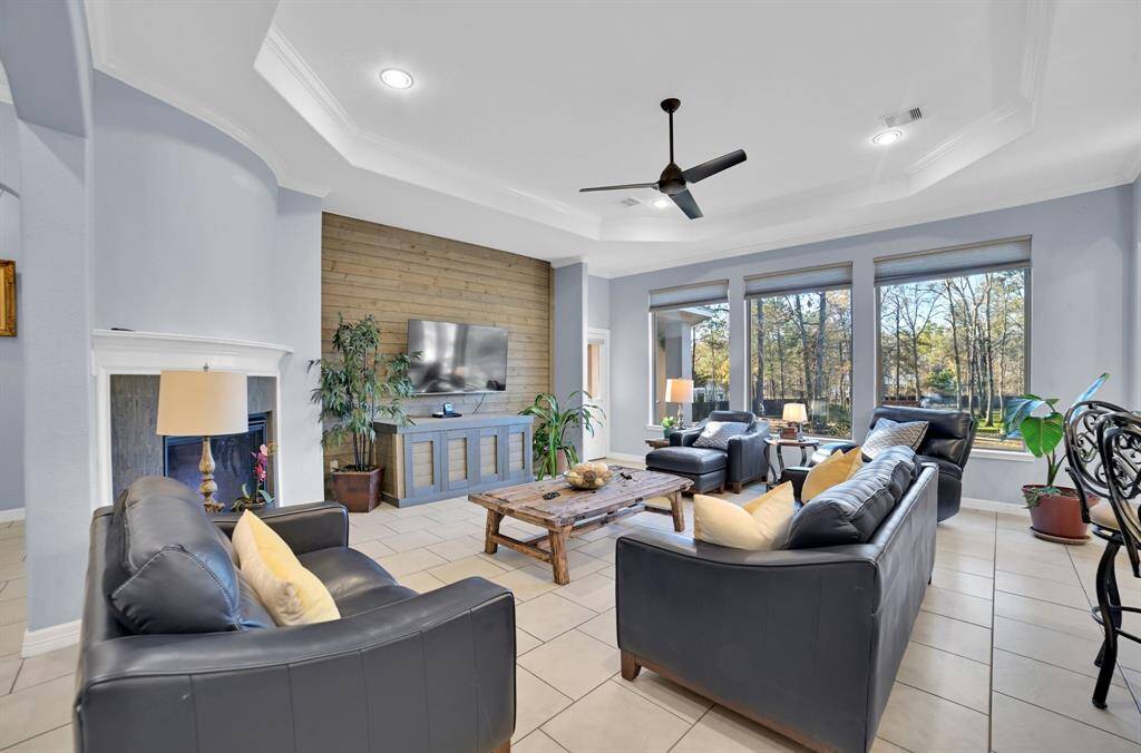Step into a peaceful and elegant living room with a sophisticated, open design. The space is bathed in natural light thanks to a large wall of windows. These windows frame a stunning view of an amazing outdoor area.
