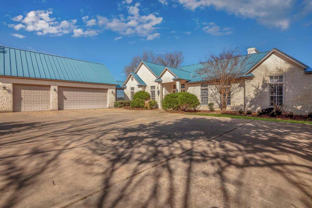 Home has a circular driveway with a substantial concrete parking area