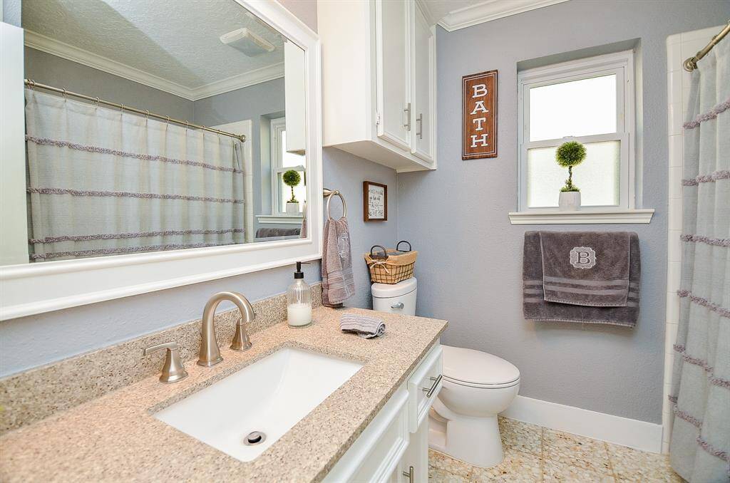 The hall bathroom is light & bright & it features an upgraded framed mirror.