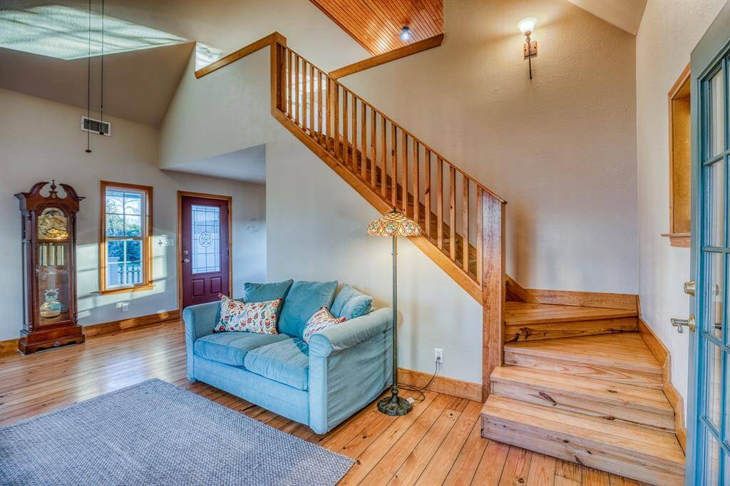 Living area with stairway leading to the 2nd level loft overlooking the grand limestone fireplace.