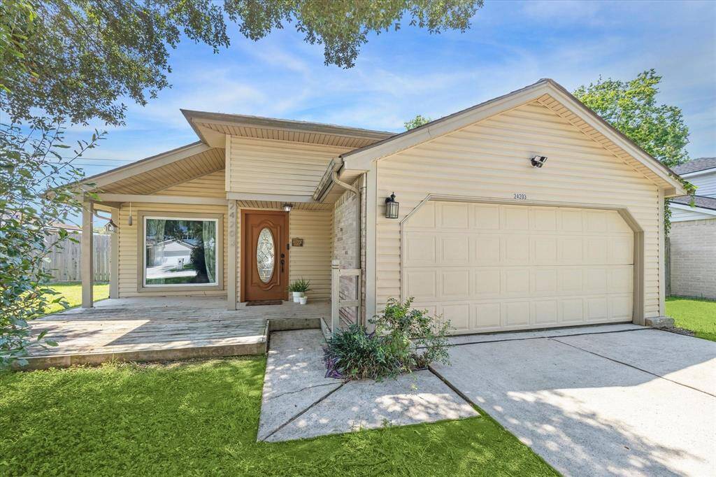 The front of the home has charming curb appeal with the front deck and mature tree.