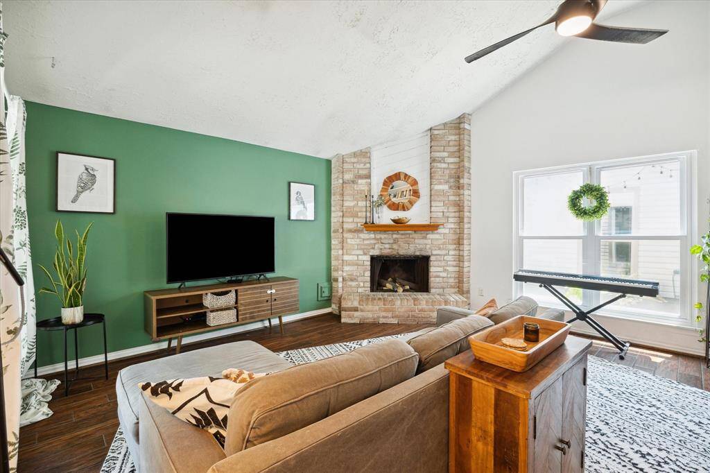 The living room offers the best of both worlds with high ceilings and a cozy brick fireplace