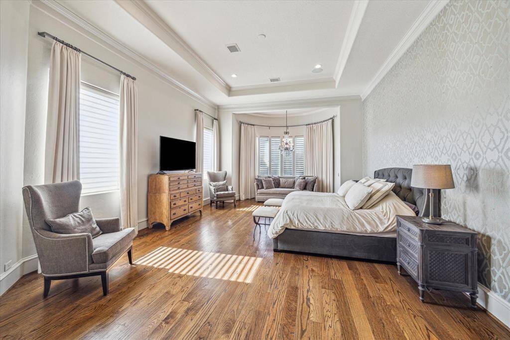 First floor master suite with sitting room and views of the spectacular backyard. Wood floors and wallpapered accent wall.