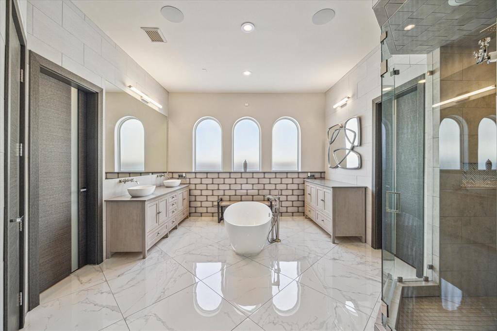 Completely remodeled master bath with freestanding tub, large walk in shower, custom cabinetry and interior doors.