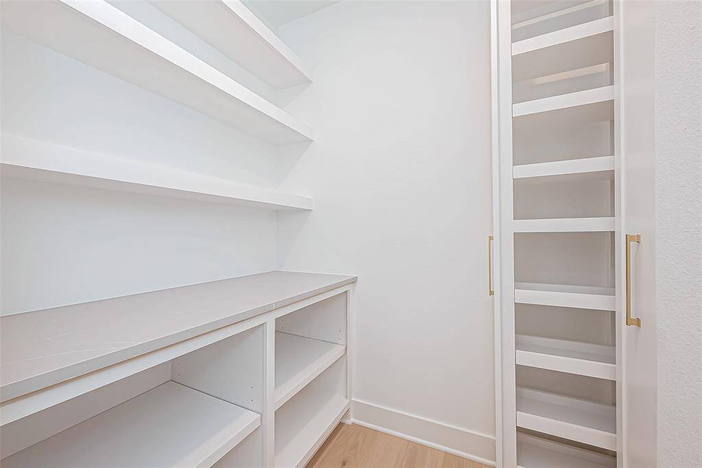spacious pantry with prep space and custom cabinets, offering ample storage space.