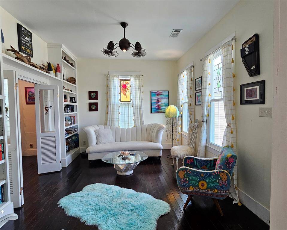 As you are welcomed into the home you notice the original hardwood floors, high ceilings, built in shelving and remote-control fans above. Curtains will stay.