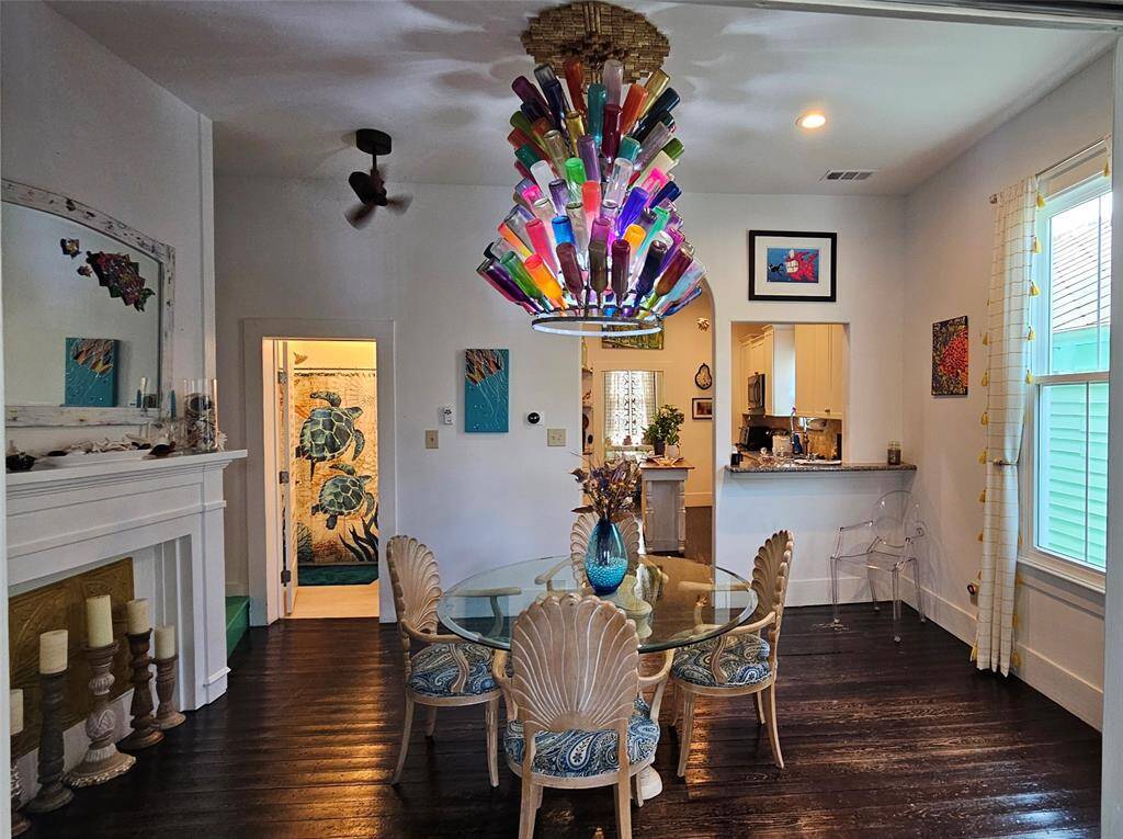 Step into the Dining Room with a Mock Fireplace, Original Hard Wood Flooring, High Ceilings, Remote Control Fan and Natural Lighting!
