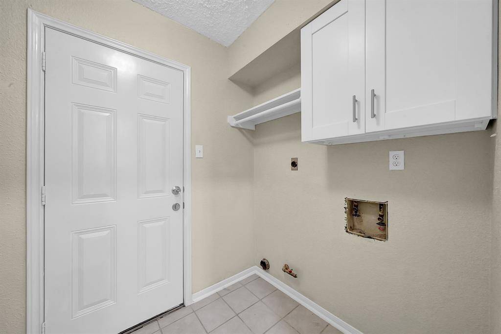 Walk in laundry room with custom organizing rack and cabinet for storage