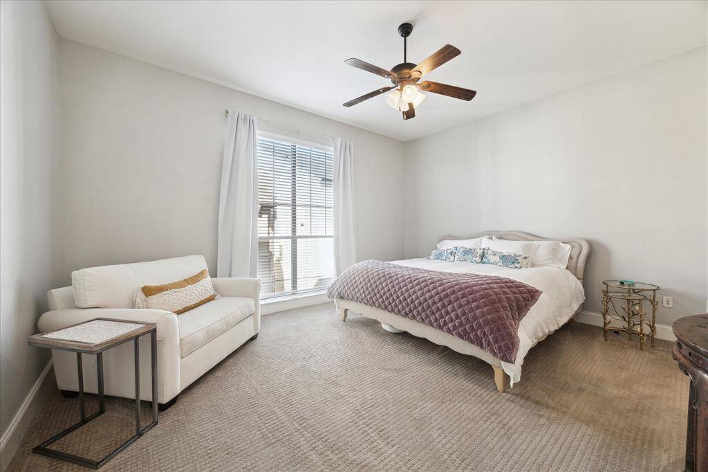 The expansive primary suite is illuminated by natural light, features a ceiling fan, and offers abundant space for your bedroom furniture.