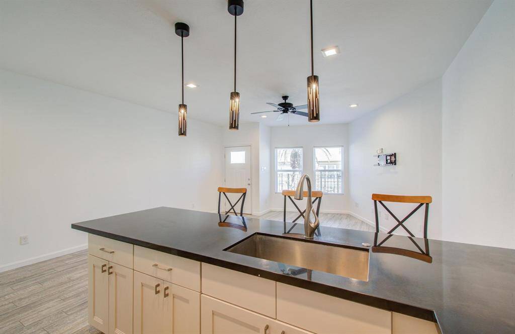 View from kitchen featuring living room with natural light from the windows, and the neutral color palette, ideal for entertaining.