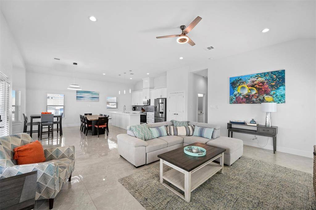 This open-concept living space is designed for both comfort and connection. With high ceilings, natural light, and a seamless flow between the kitchen, dining, and living areas, it's perfect for relaxing or entertaining.