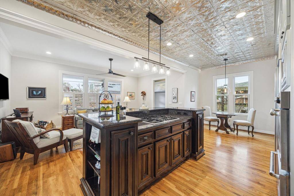 The kitchen, located at the heart of the home, boasts a rich dark cabinetry island, stunning granite countertops, a spacious breakfast bar, and a gas cooktop, making it both functional and stylish for all your culinary needs.