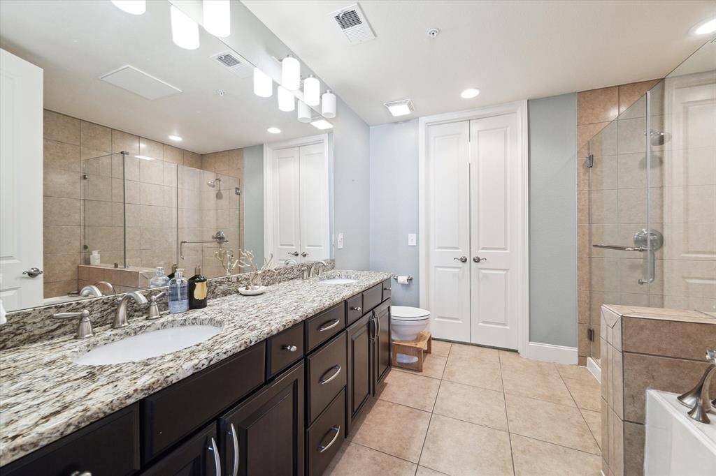 The en suite primary bath boasts double sinks, ample storage space, and excellent lighting.