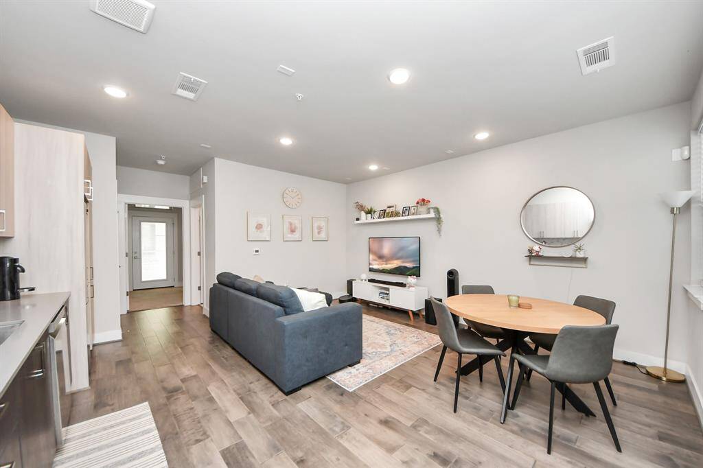 This open-concept living area features a cozy seating arrangement, modern furnishings.