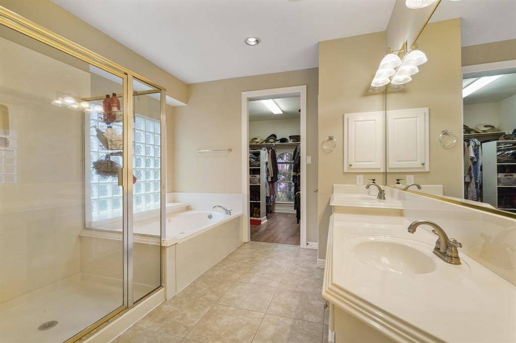 This incredible Primary Bathroom is complete with a large garden style tub, beautiful glass enclosed shower, and a large window with privacy glass providing natural light.