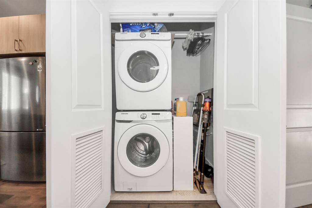 This photo shows a compact laundry area with a stacked washer and dryer inside a closet.