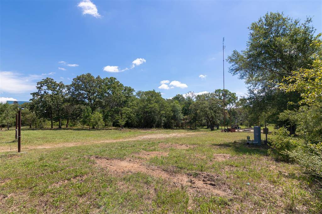 View from the front right of the property showing the driveway and acreage.