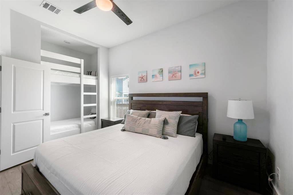 This thoughtfully designed bedroom offers plenty of sleeping space, featuring a comfortable queen bed and built-in bunk beds