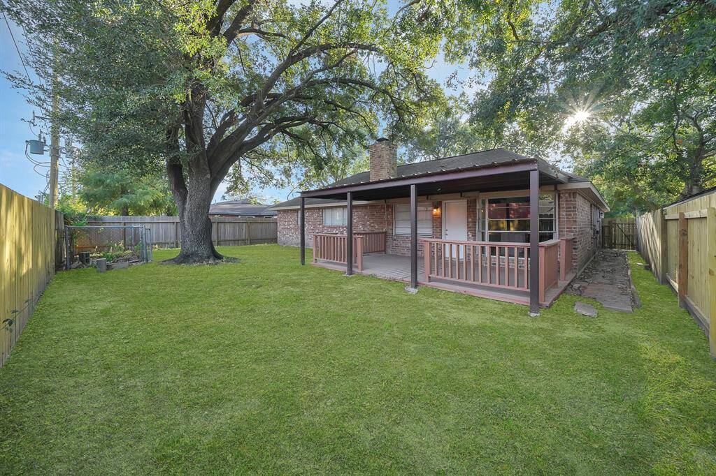 Mature trees and covered patio bring lots of shade to this backyard perfect for the hot Houston summer.