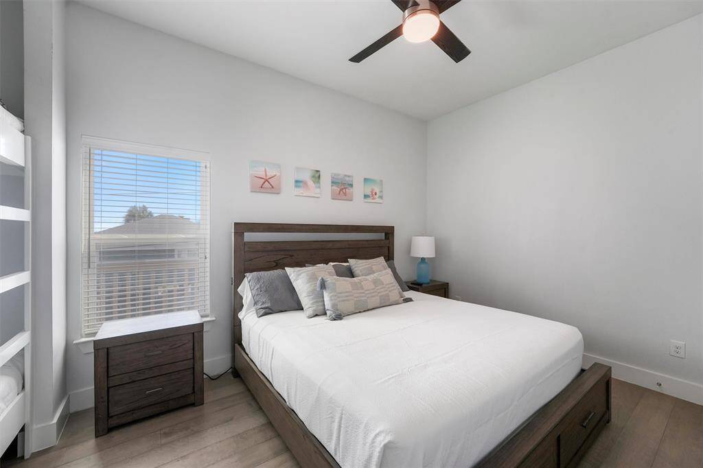 This thoughtfully designed bedroom offers plenty of sleeping space, featuring a comfortable queen bed and built-in bunk beds