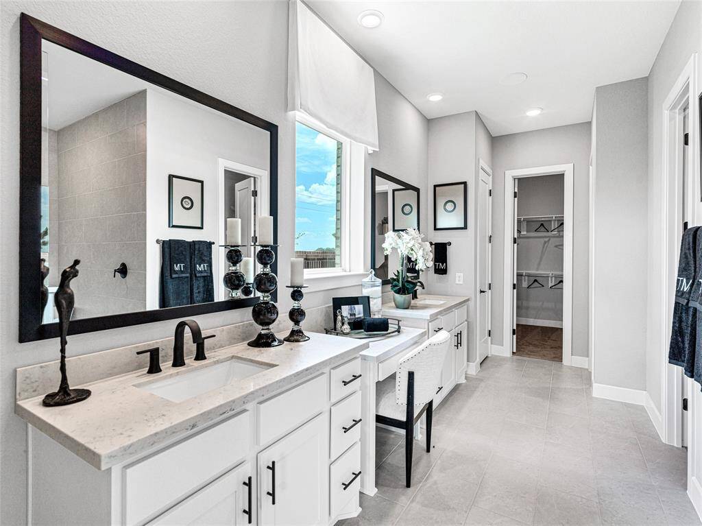 This spacious, modern bathroom with a sleek dual-sink vanity, large mirrors, and elegant black fixtures.