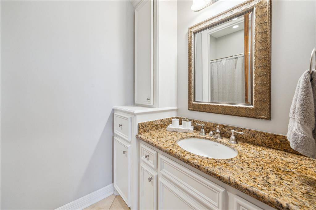 This secondary bath features granite countertops and a tub/shower combination.