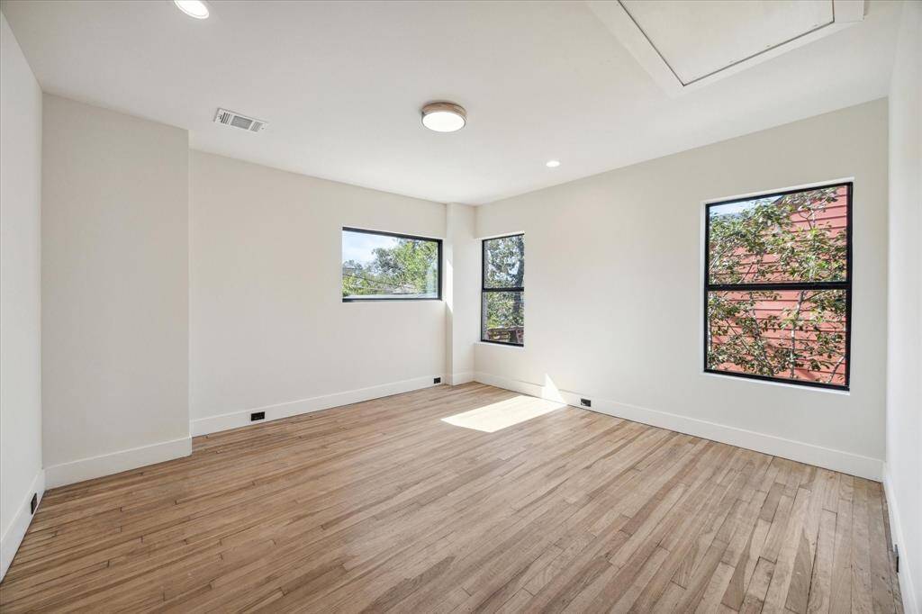 The first floor bedroom has an adjoining den with direct access to the back patio deck and can serve as a guest suite or a home office.