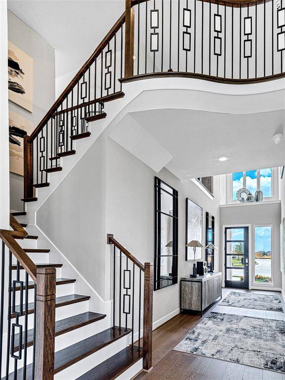 This inviting entryway features a grand staircase with elegant wood and iron railings.
