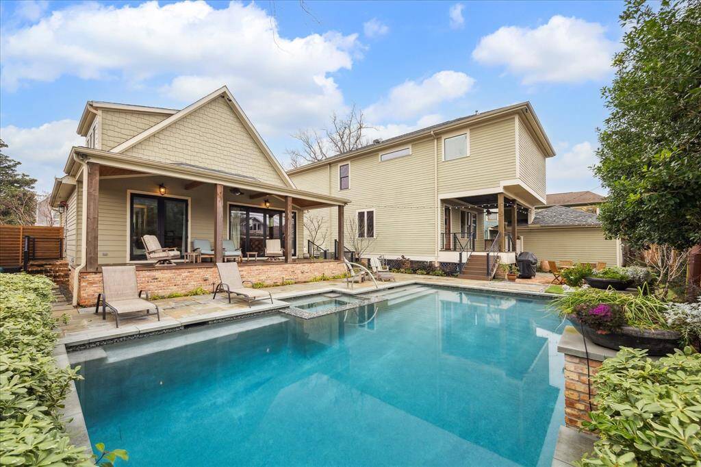 Check out this incredible pool house! It boasts a sparkling pool right in front, complemented by a charming porch and large windows that offer beautiful views of the outdoor space.
